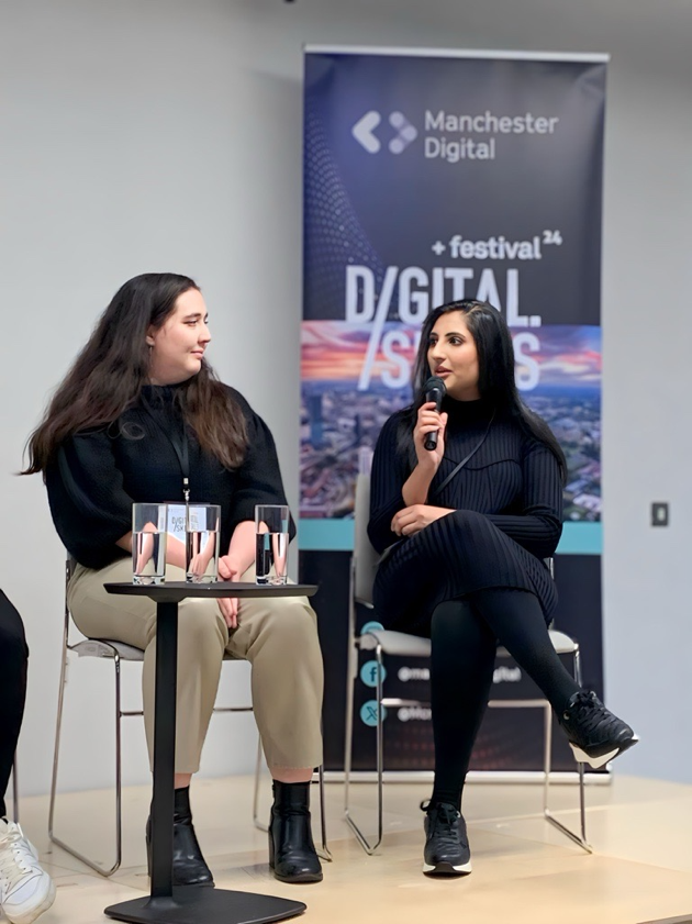 Two women sitting in chairs talking

Description automatically generated